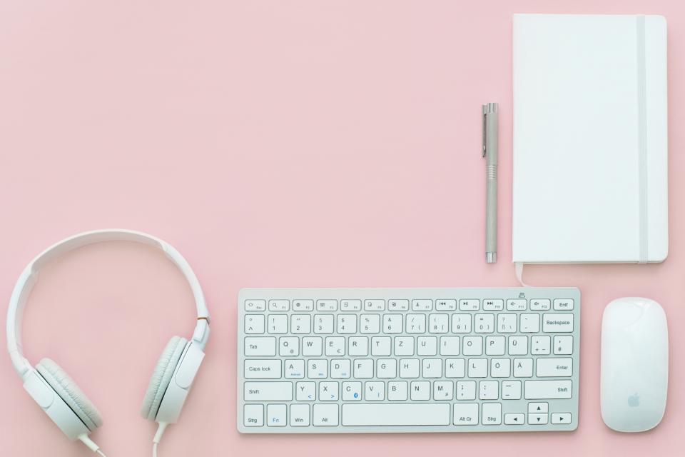 A notebook, pen and keyboard laid out for planning